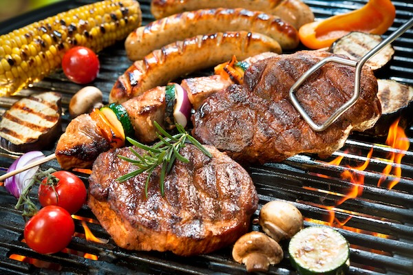 Assorted meats and veggies grillings on a BBQ