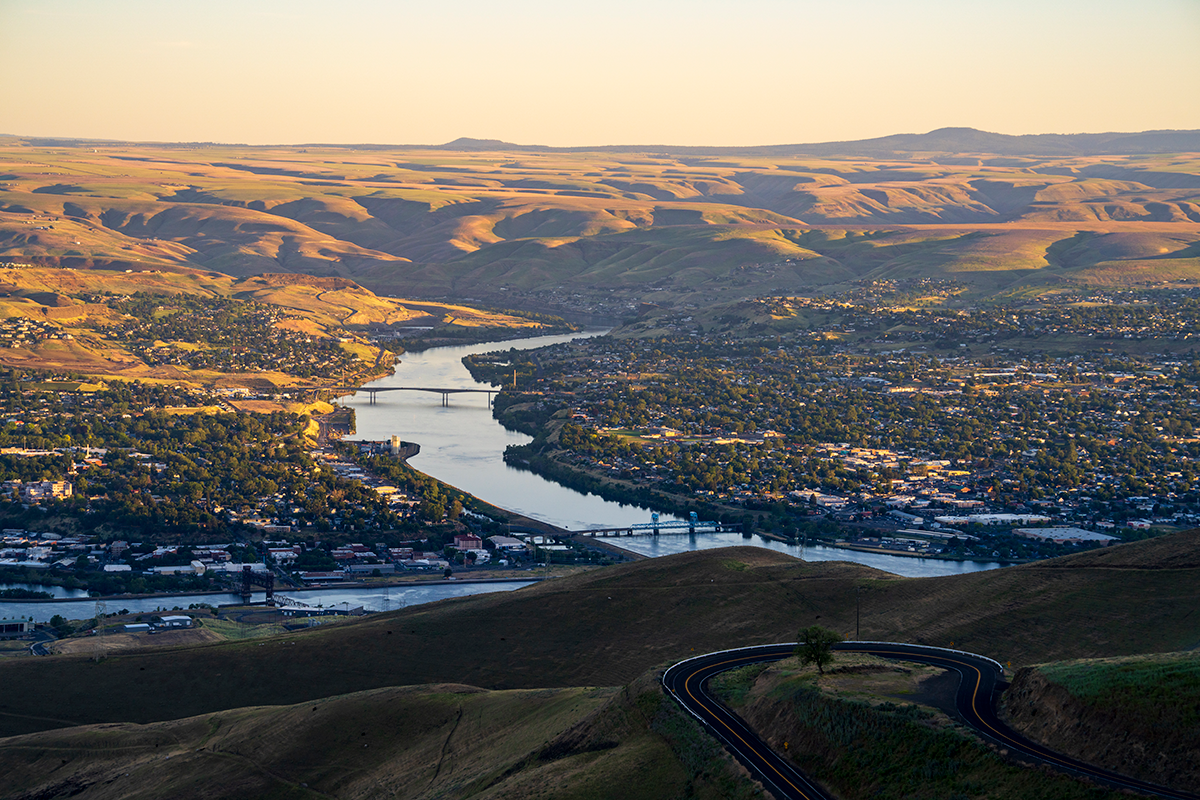 City on river surrounded by hills.