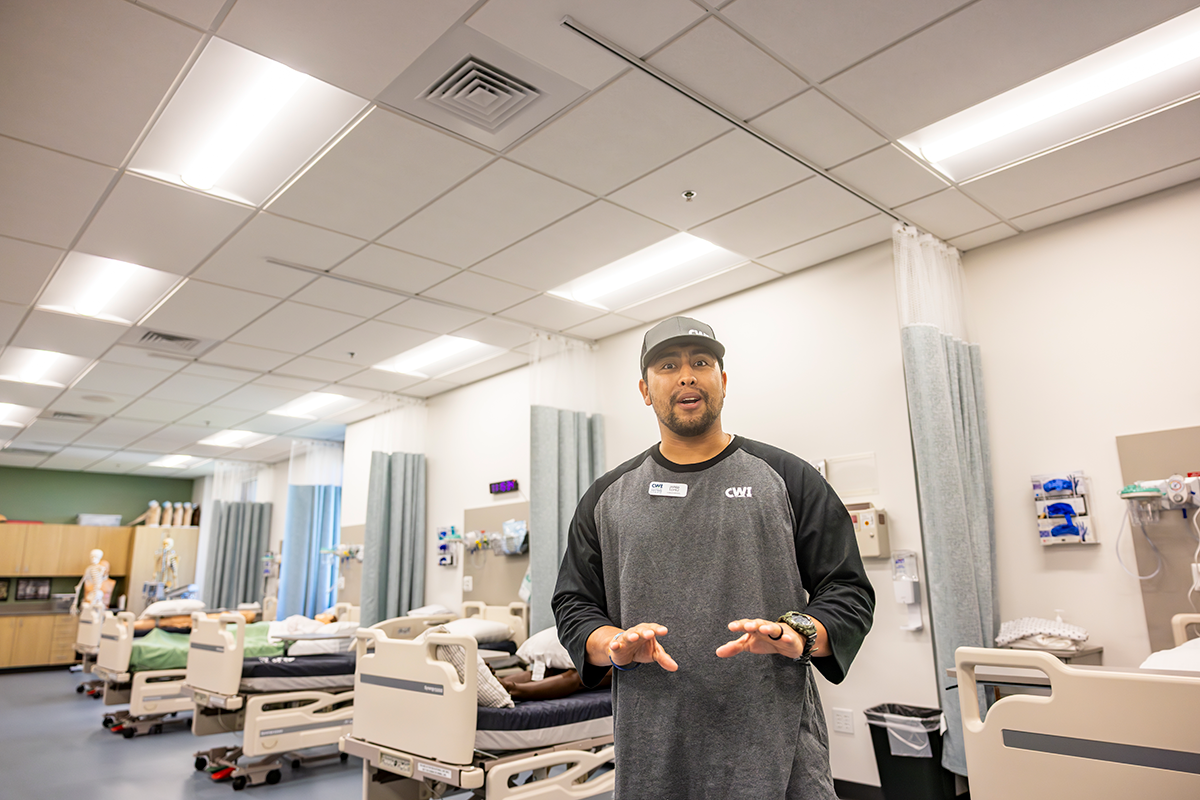 Man standing in classroom with hospital beds