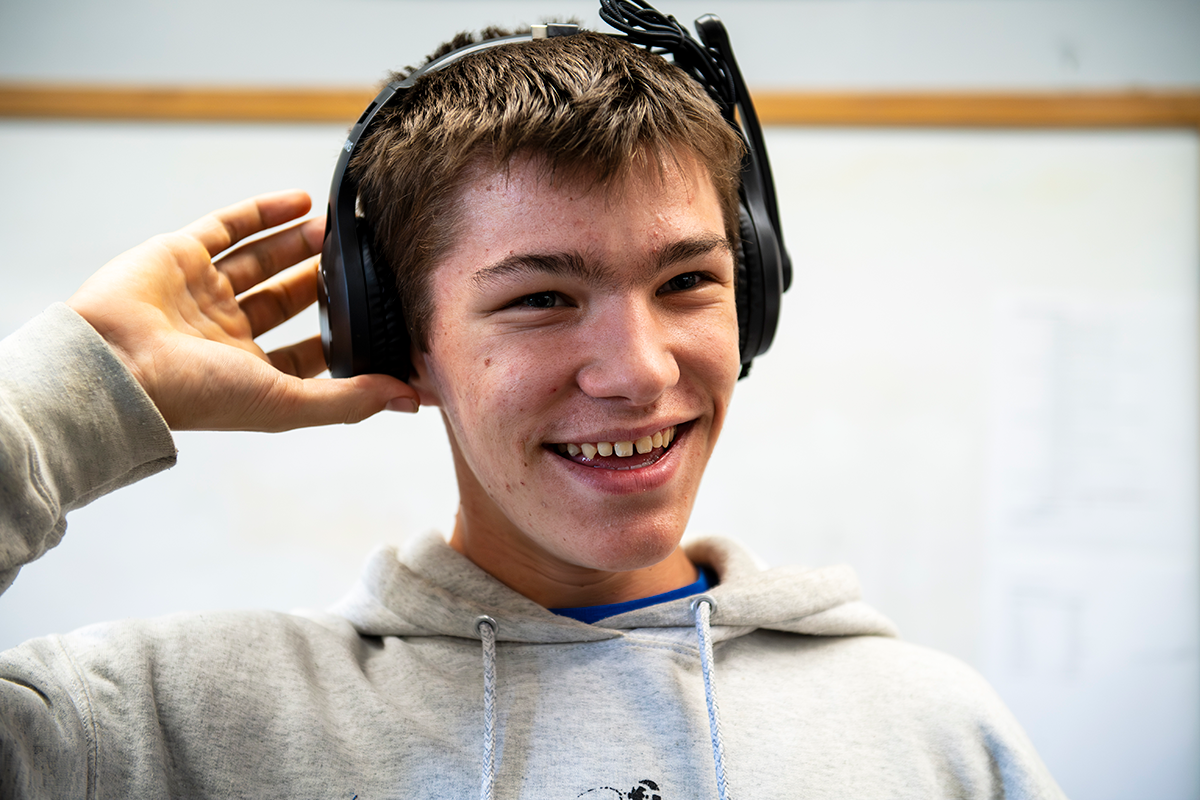 Student with new headphones on smiling.