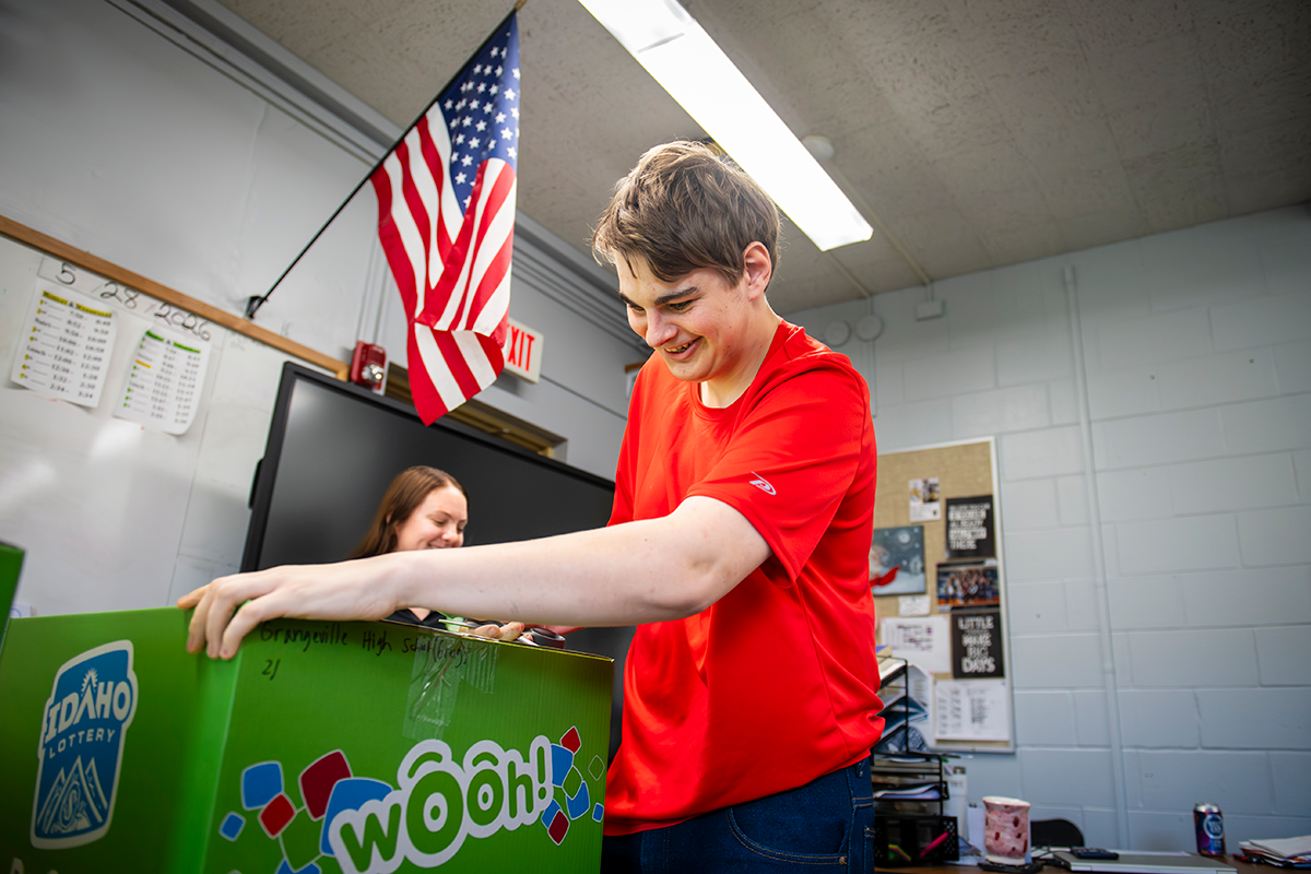 Student opening package from the Idaho lottery.