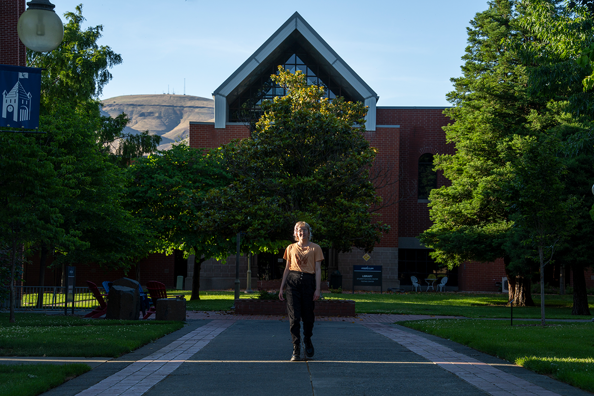 Person walking in front of college building.